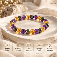 A beaded stretch bracelet displayed on a textured ceramic dish, featuring alternating purple, amber-yellow, and metallic gray beads. The image includes informational icons at the bottom detailing product features like 8MM beads, natural crystals, lab certification, double elastic, and unisex design.