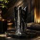 orthoceras stone sculpture on a dark surface with a candle in the background